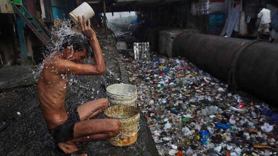 Hindistan'da en düşük kast üyesi bir Sudra, çöplükte yıkanıyor.